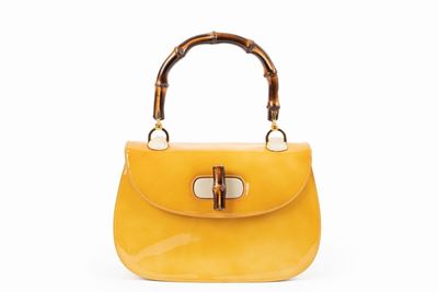 Borsa in vernice zafferano con inserti in pelle e manico in bambù