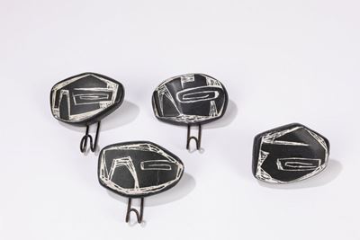 Quattro appendiabiti in ceramica smaltata con supporto in metallo