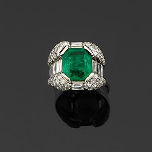 A platinum, emerald and diamond ring