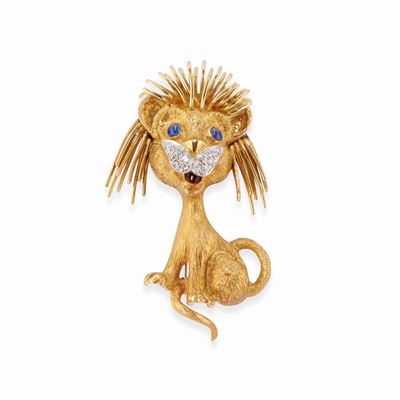 Spilla in oro bicolore 18k, raffigurante un leoncino con diamanti e zaffiri