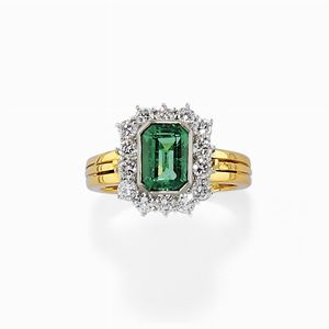 A 18K two color gold, emerald and diamond ring