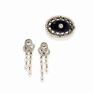 A 18k white gold, silver, onyx, pearl and diamond lot of two jewels, defects