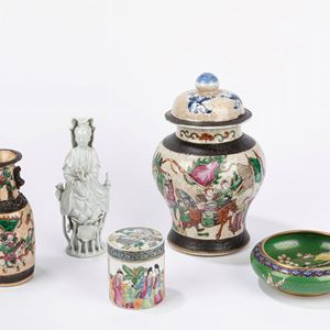 Lotto composto da una potiche e un vasetto in porcellana Nanchino, una sculturina in porcellana blanc de chine, una ciotola in smalto cloisonné e una piccola scatola con coperchio in porcellana canton decorata con scene di palazzo. Cina, secolo XX