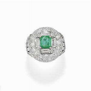 A platinum, emerald and diamond ring